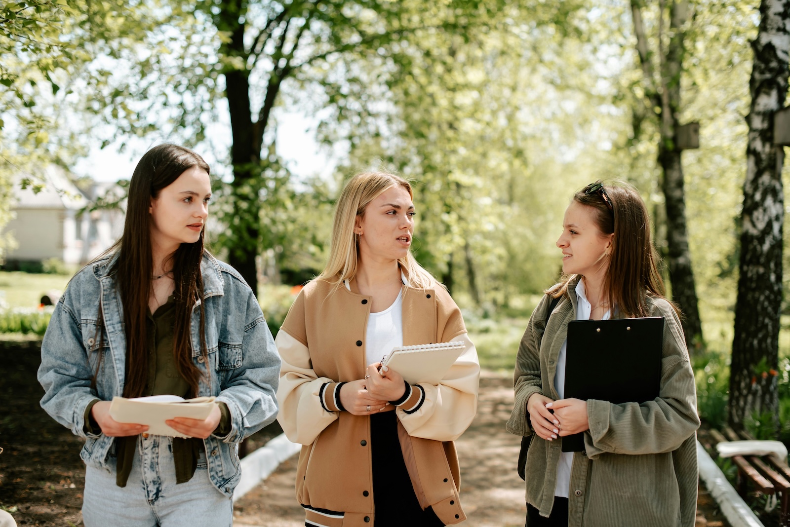 Three girls walking outside on a campus